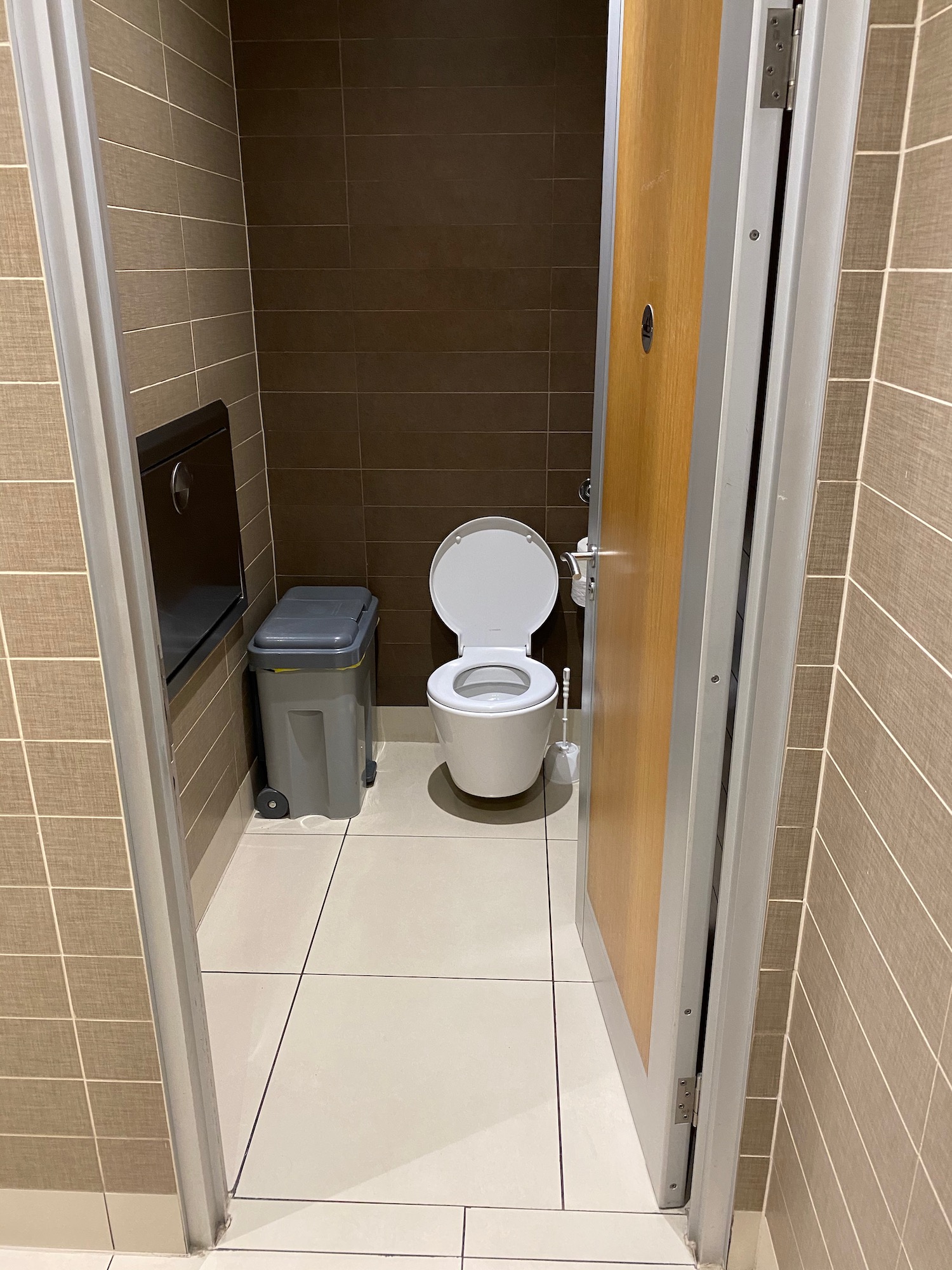 a bathroom with a toilet and trash can