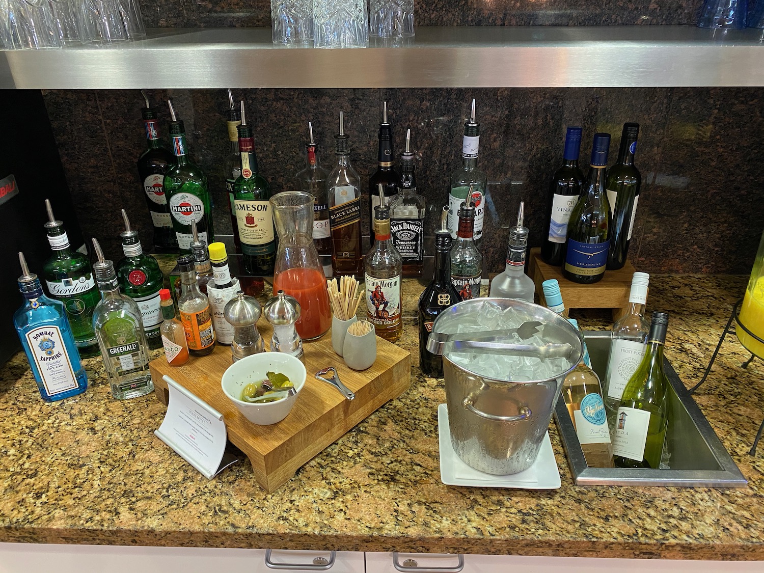 a counter with bottles of alcohol and a bucket of food