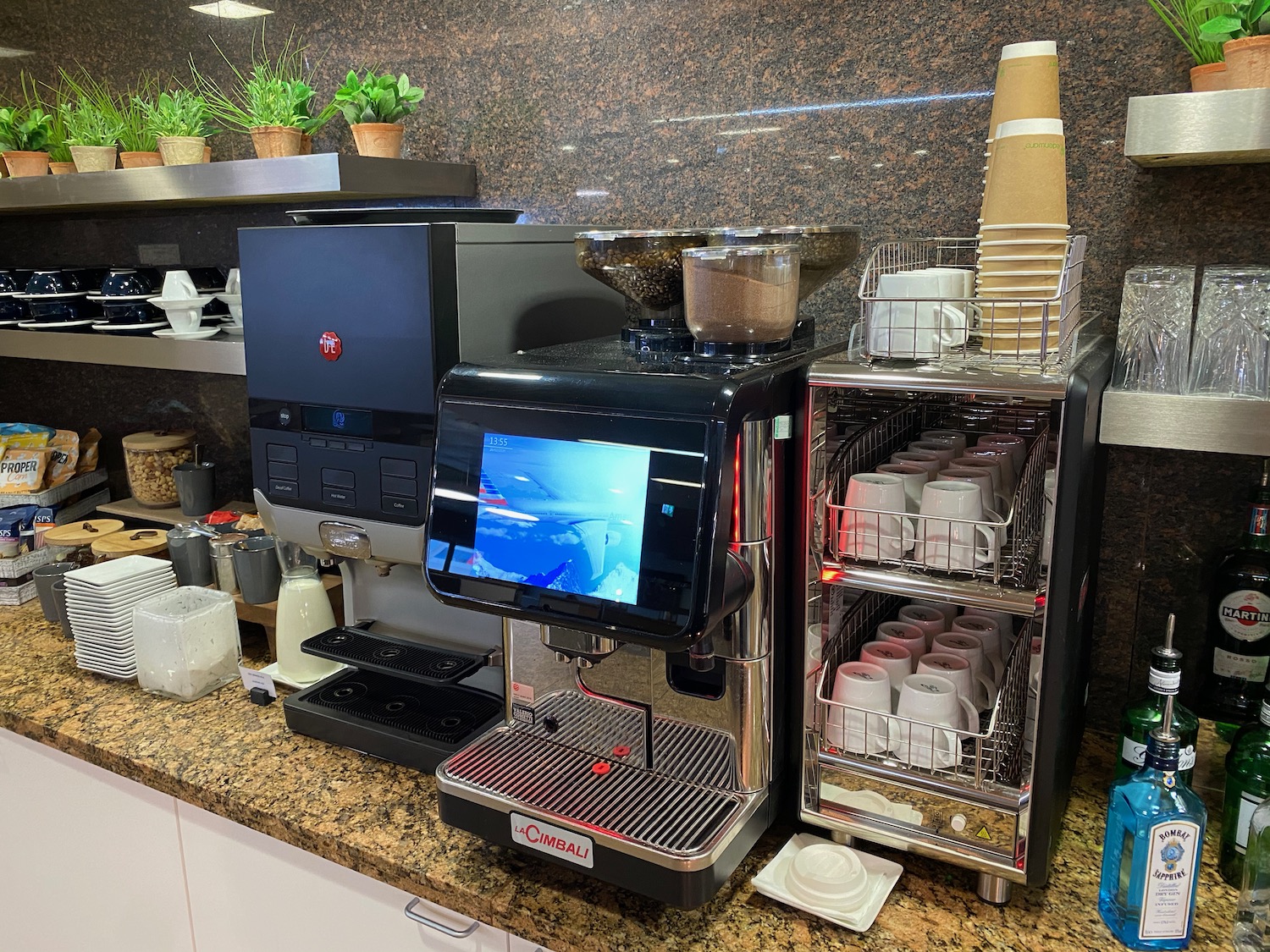 a coffee machine with a screen and cups on top