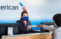 a woman wearing a mask handing money to a customer