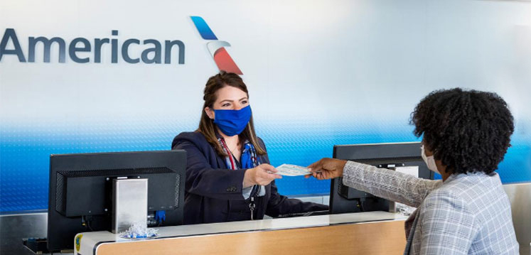 a woman wearing a mask handing money to a customer