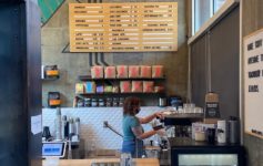 a woman standing behind a counter in a coffee shop