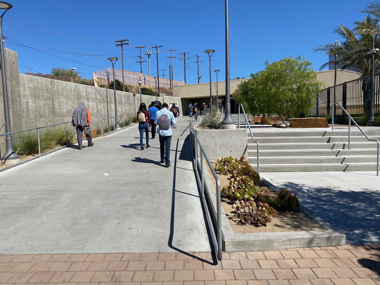 a group of people walking down a sidewalk