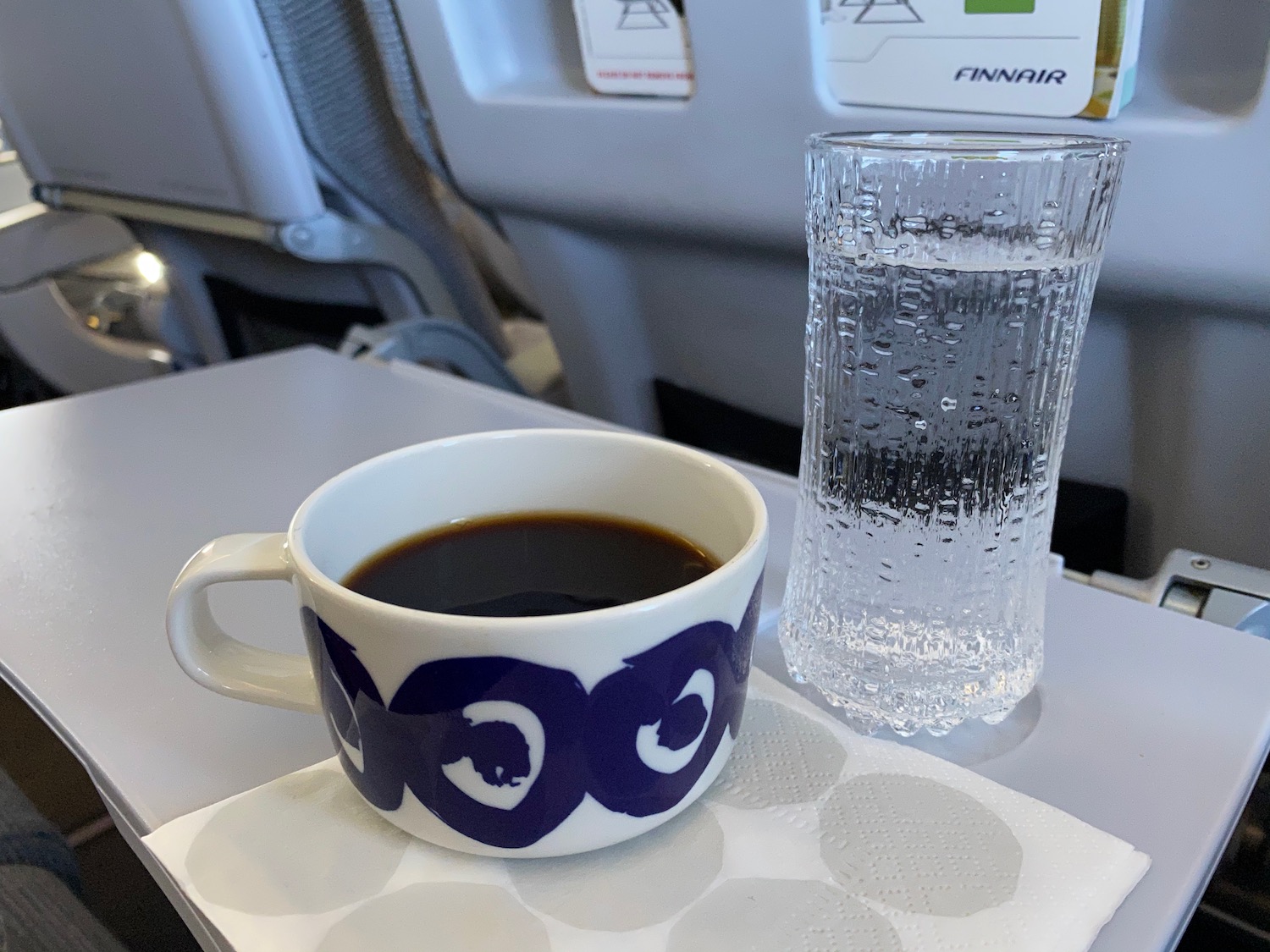 a cup of coffee and a glass of water on a tray