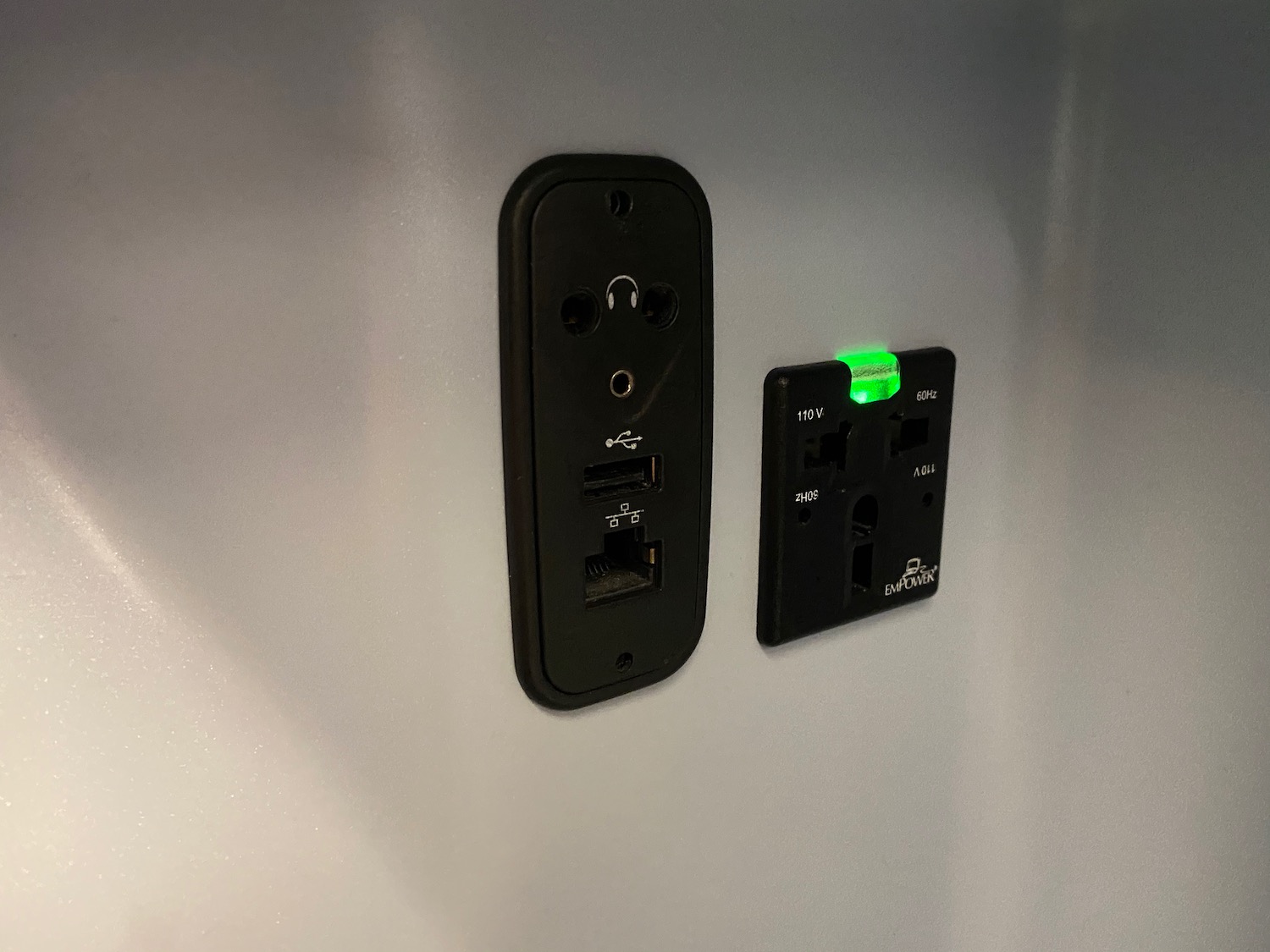 a black outlet with a green light on the wall