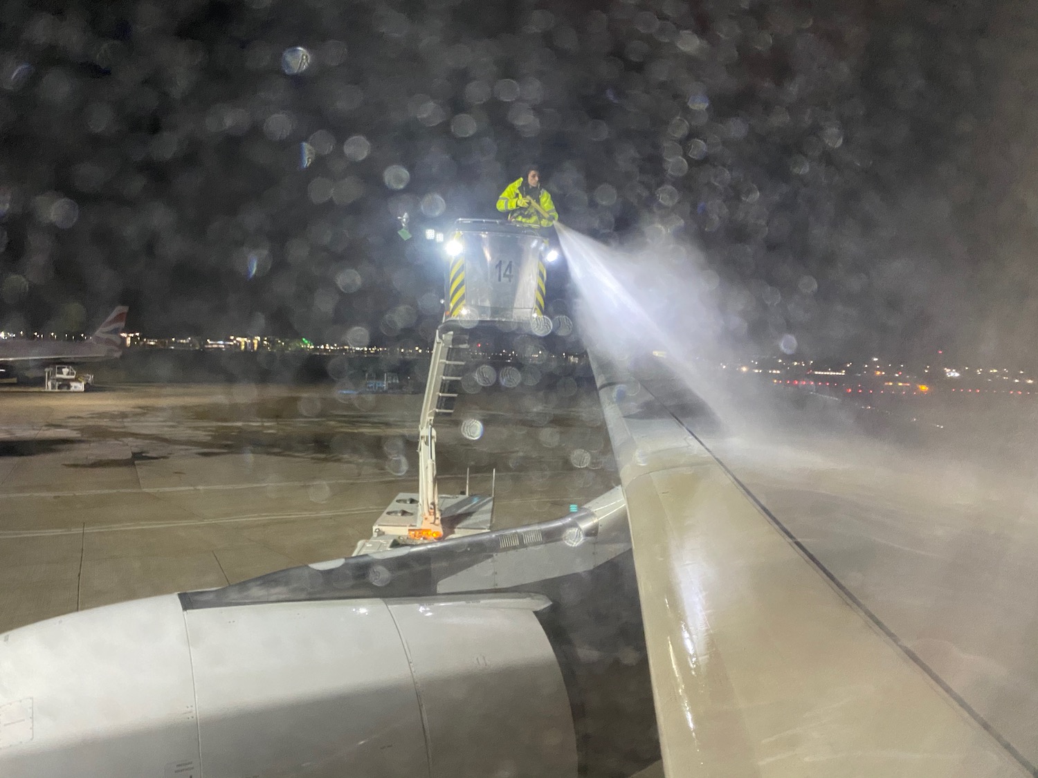 a man spraying water on an airplane wing