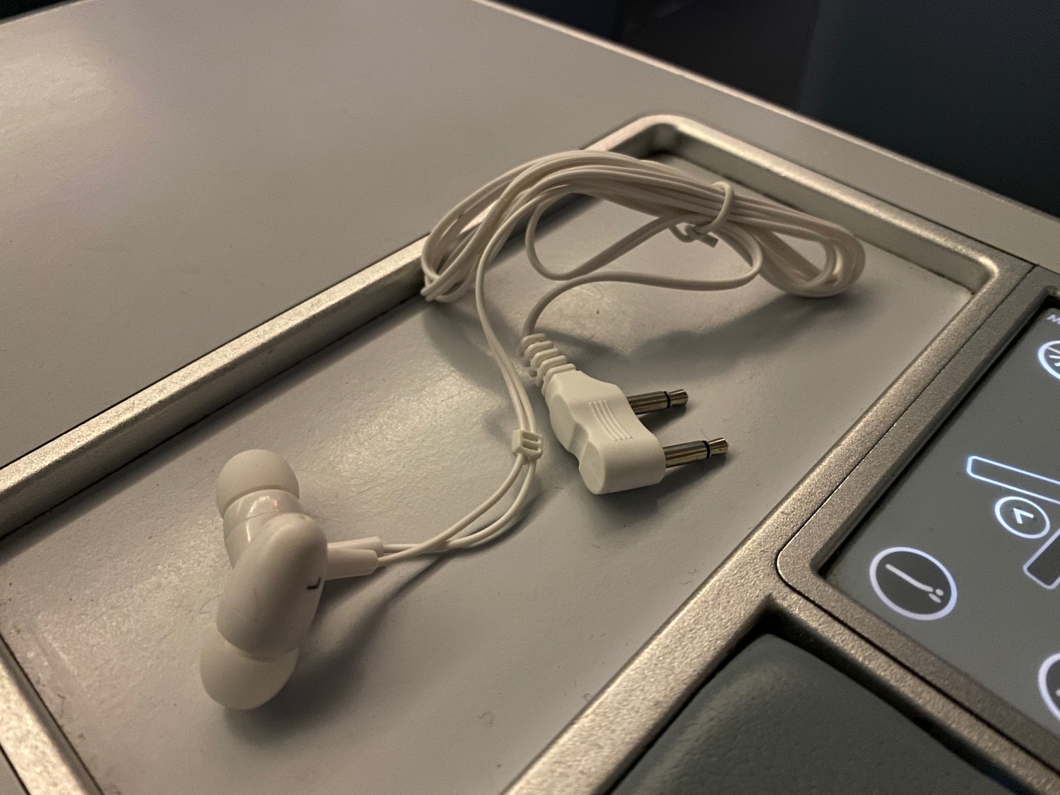 a white earbuds on a grey surface