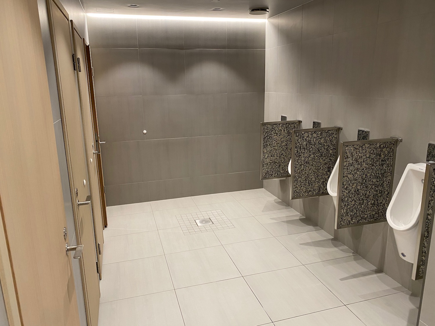 a bathroom with urinals and doors