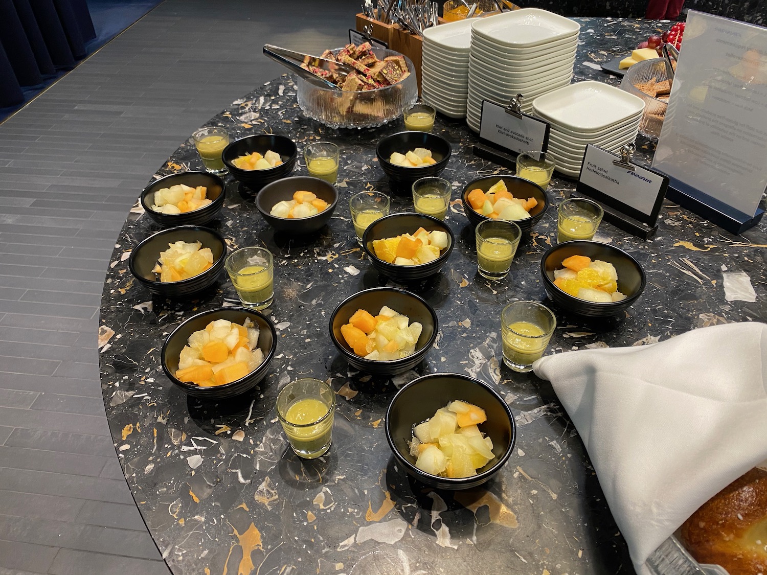 a table with bowls of fruit and drinks