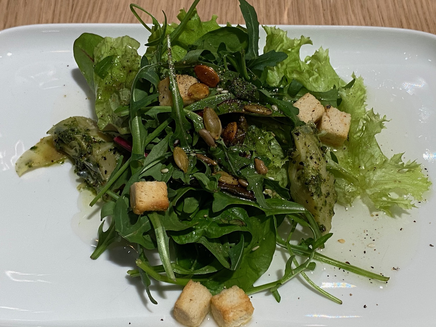 a plate of salad on a wood table