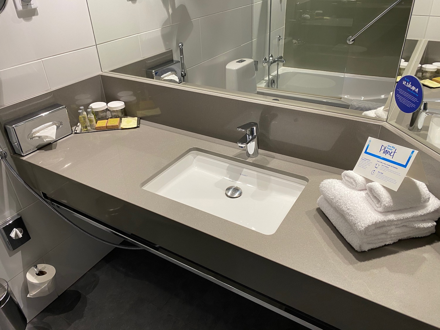 a bathroom sink with towels and a mirror