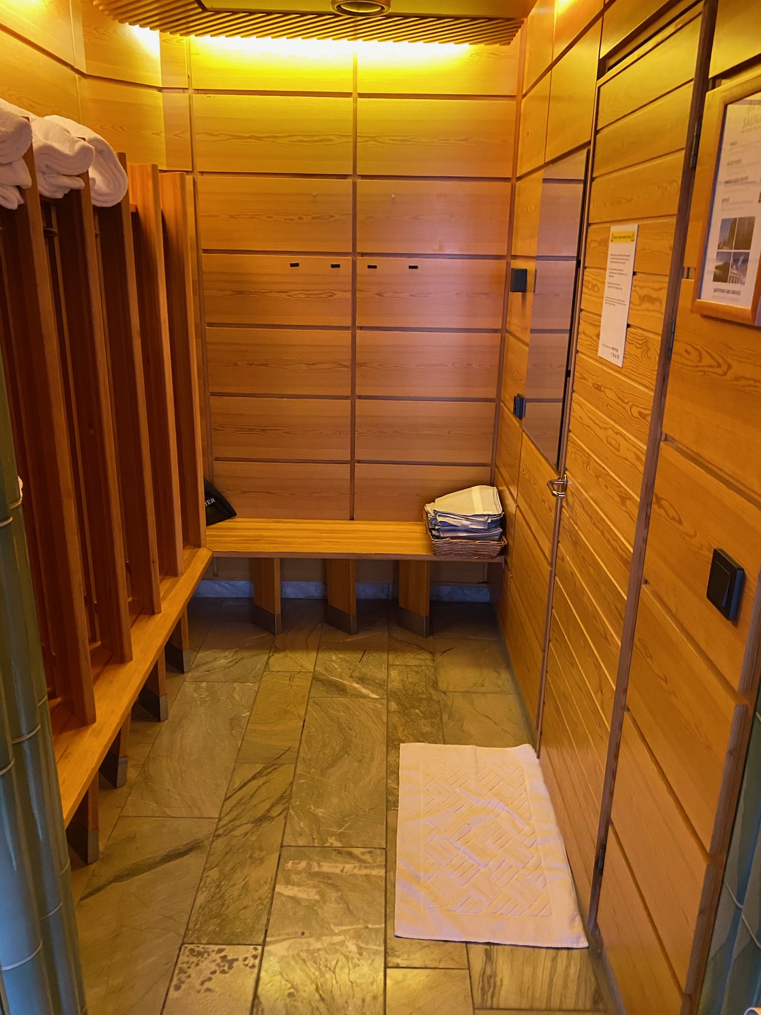 a wooden room with a bench and towels