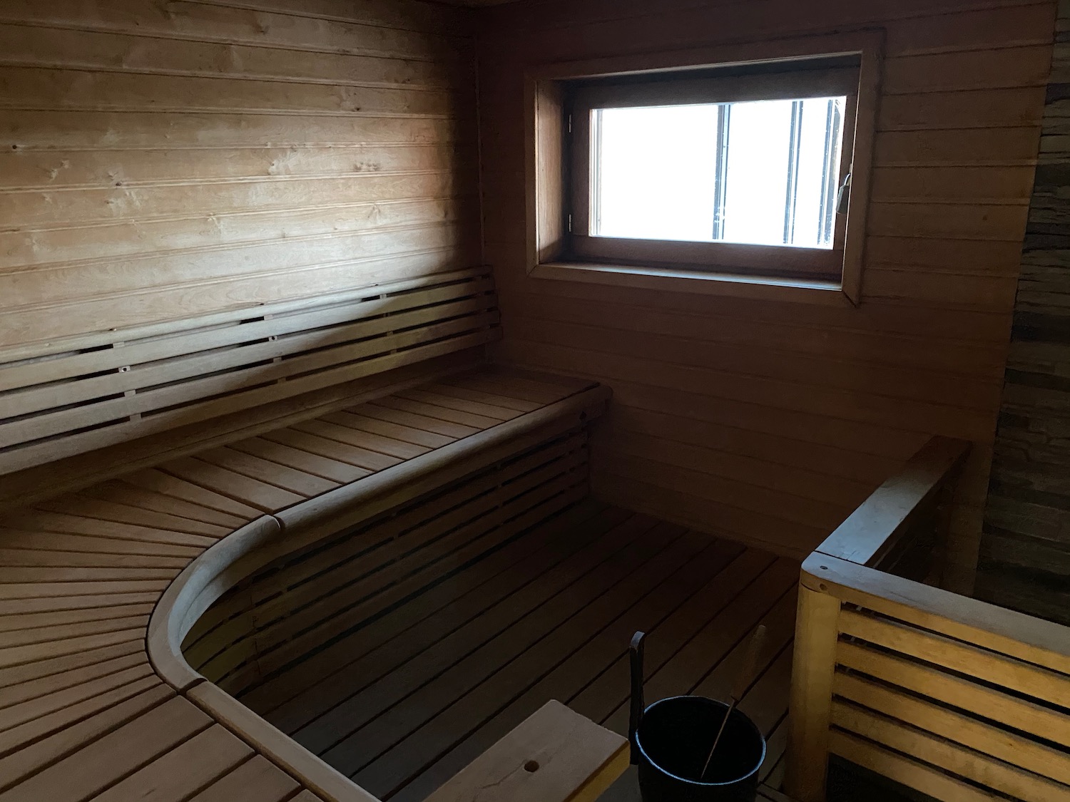 a wooden sauna with a bucket and a window
