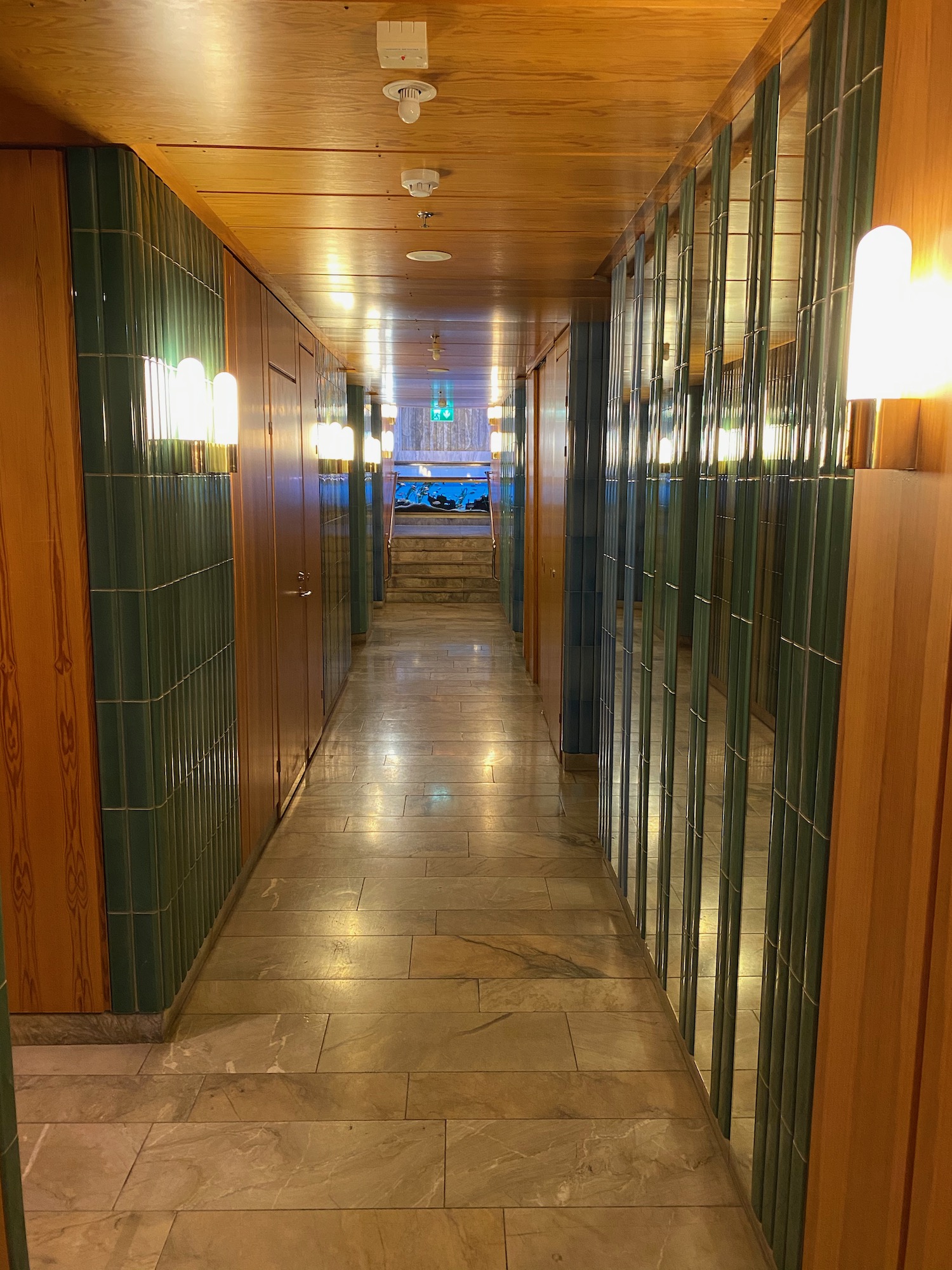 a hallway with green tile walls and wood paneling