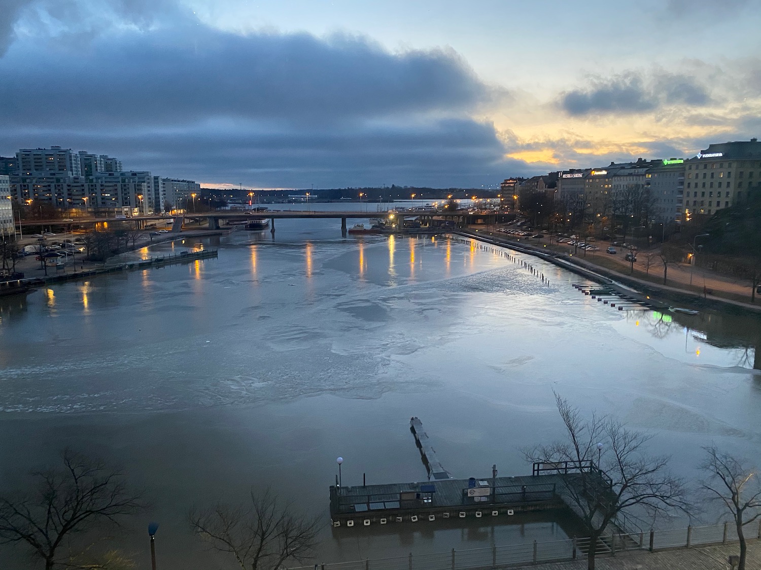 a river with a bridge and buildings in the background