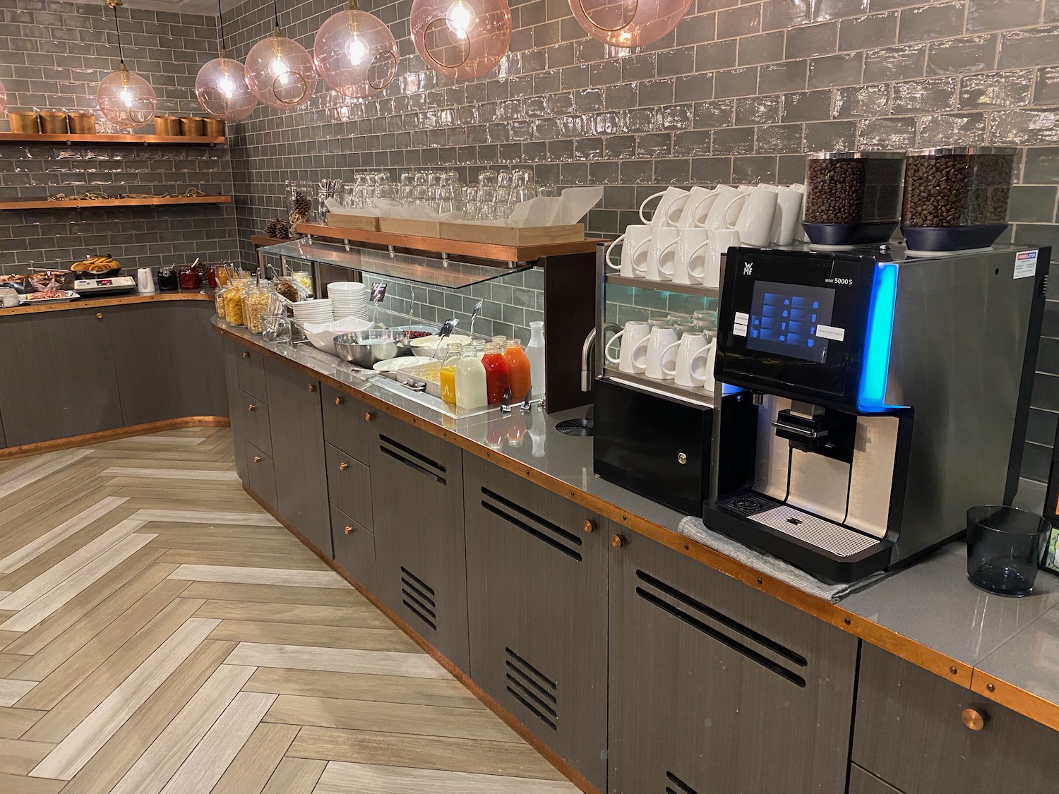 a counter with a coffee machine and coffee cups