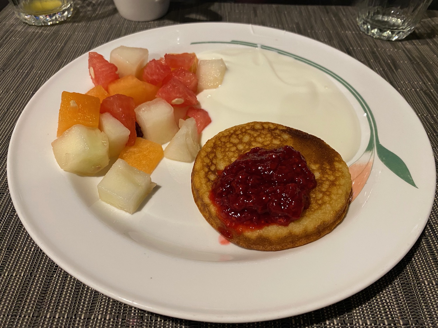 a plate of food with a small pancake and fruit