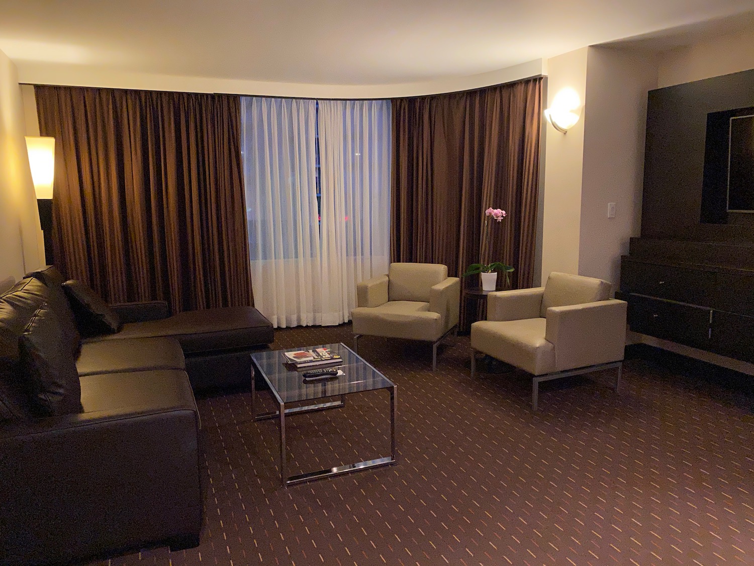 a living room with brown curtains and a couch and a coffee table