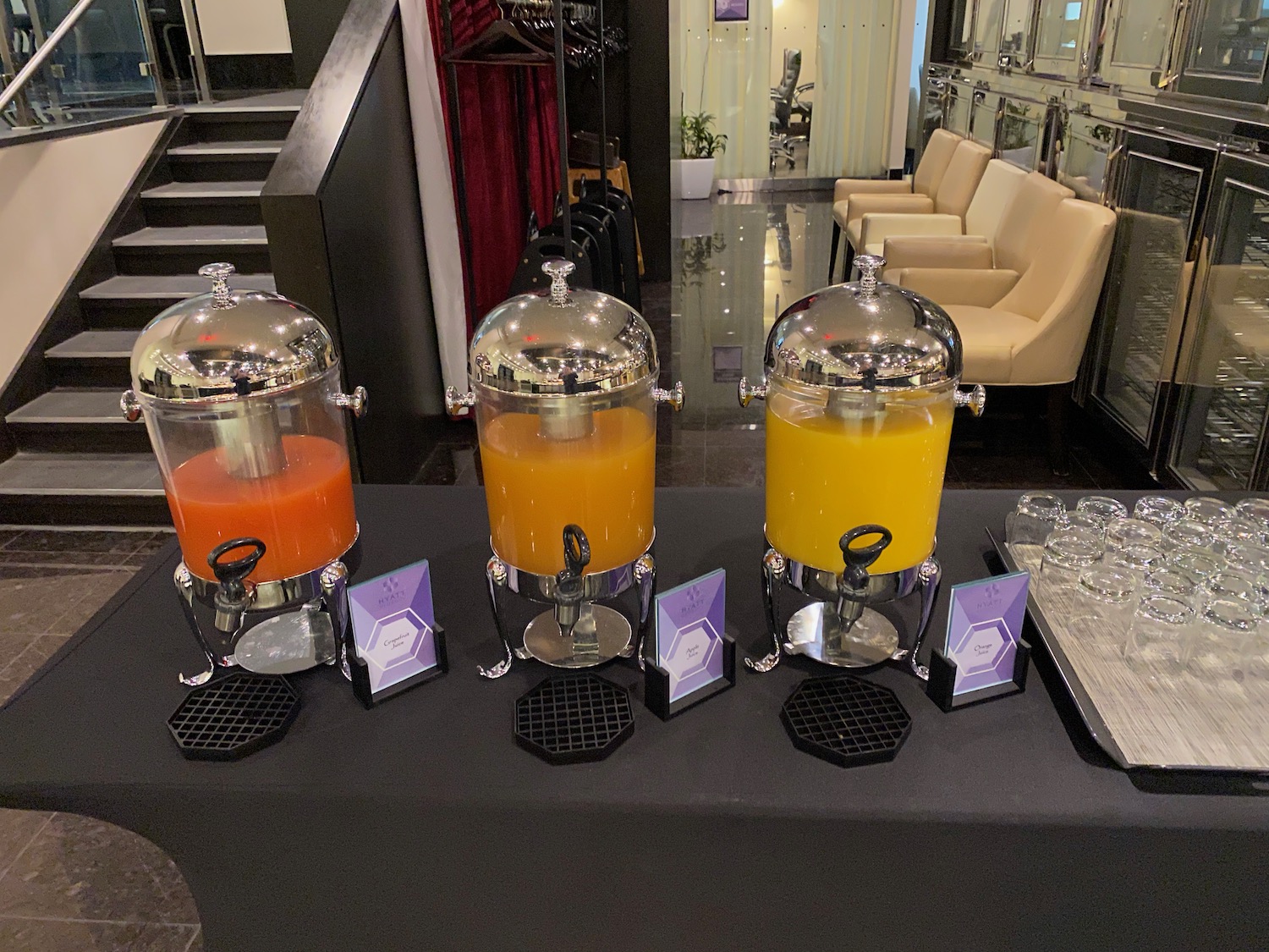 a group of juice dispensers on a table