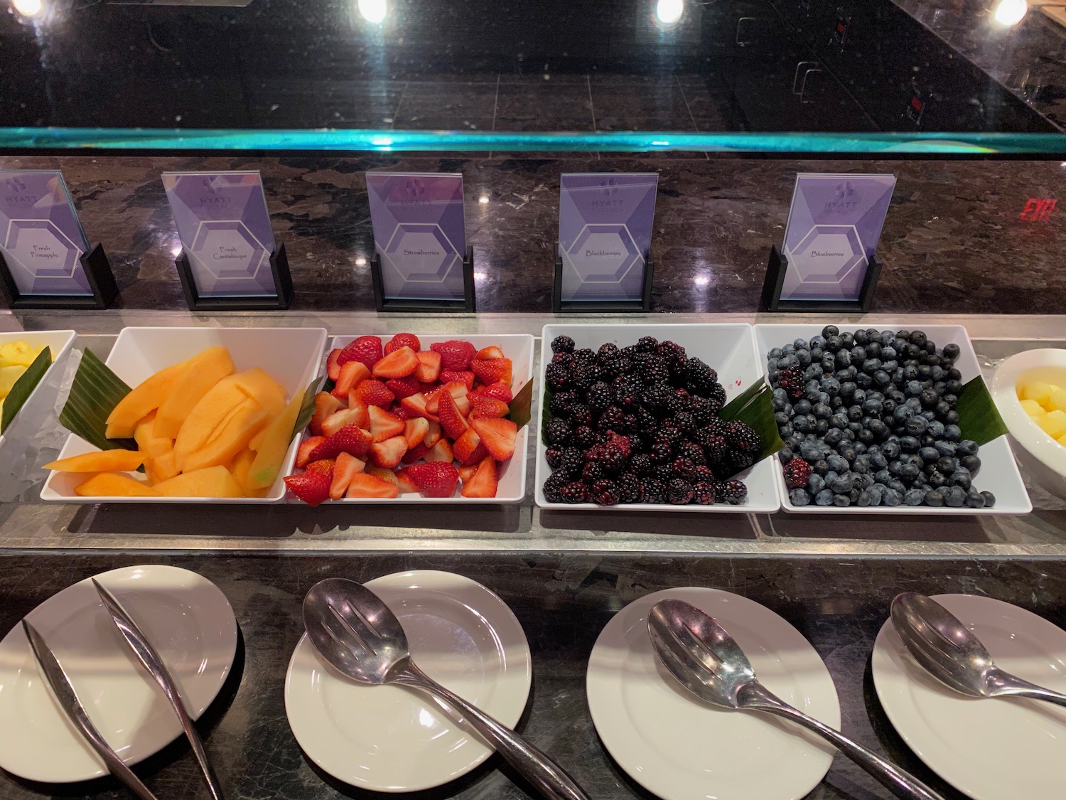 a group of plates with different types of fruit in bowls