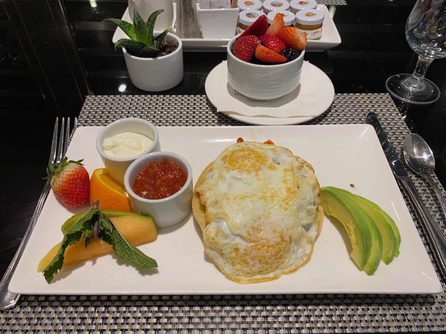 a plate of food with a fried egg and fruit