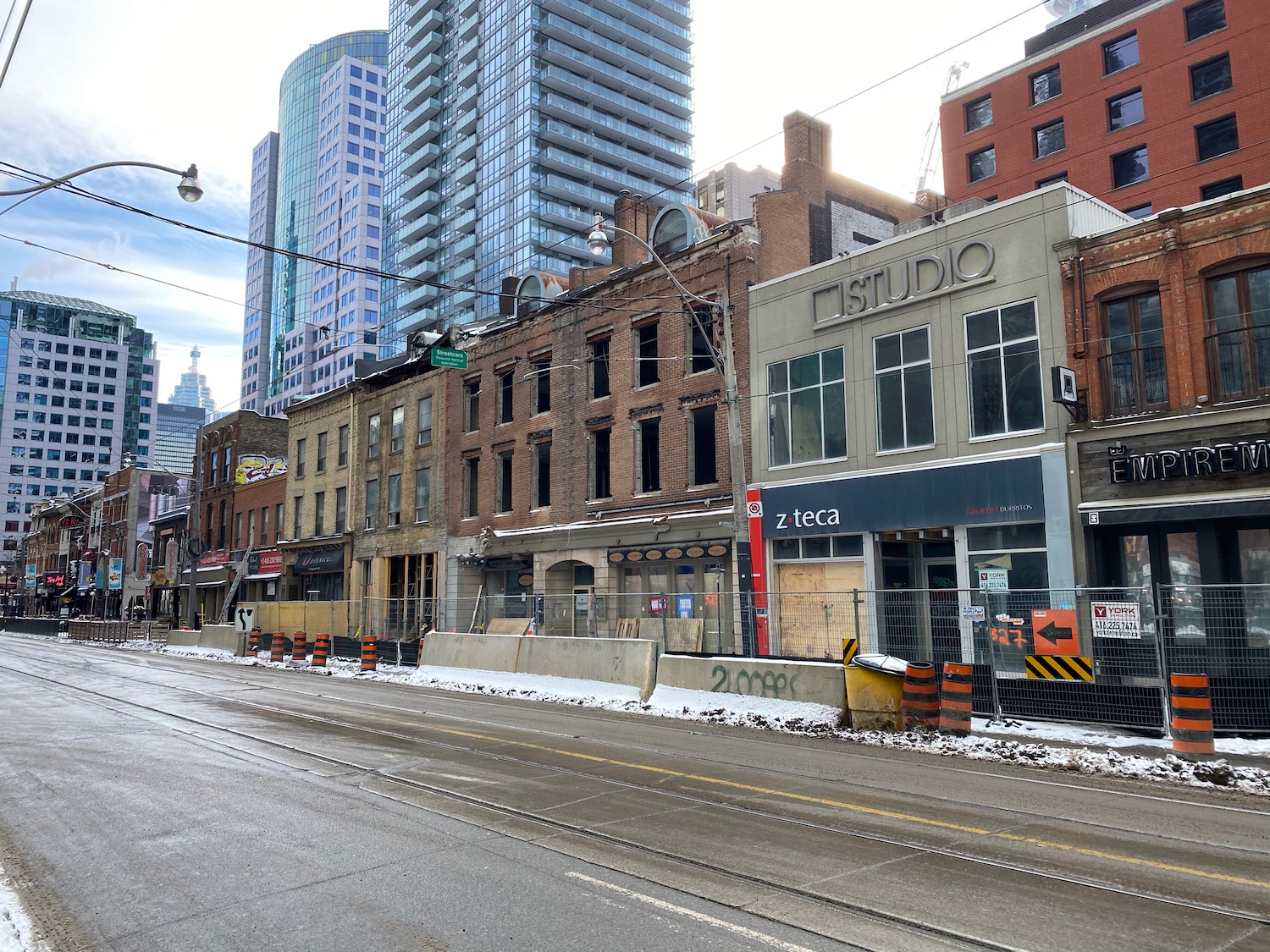 a street with buildings and a city in the background