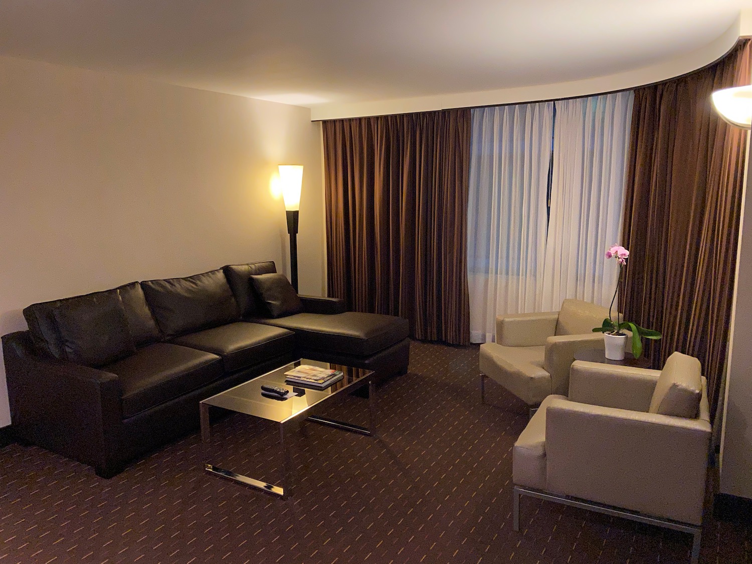 a living room with brown curtains and a couch and a coffee table