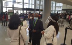 a group of people wearing face masks and standing in a room