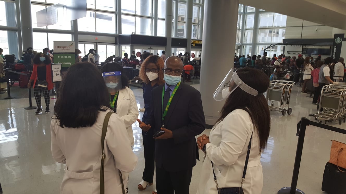 a group of people wearing face masks and standing in a room