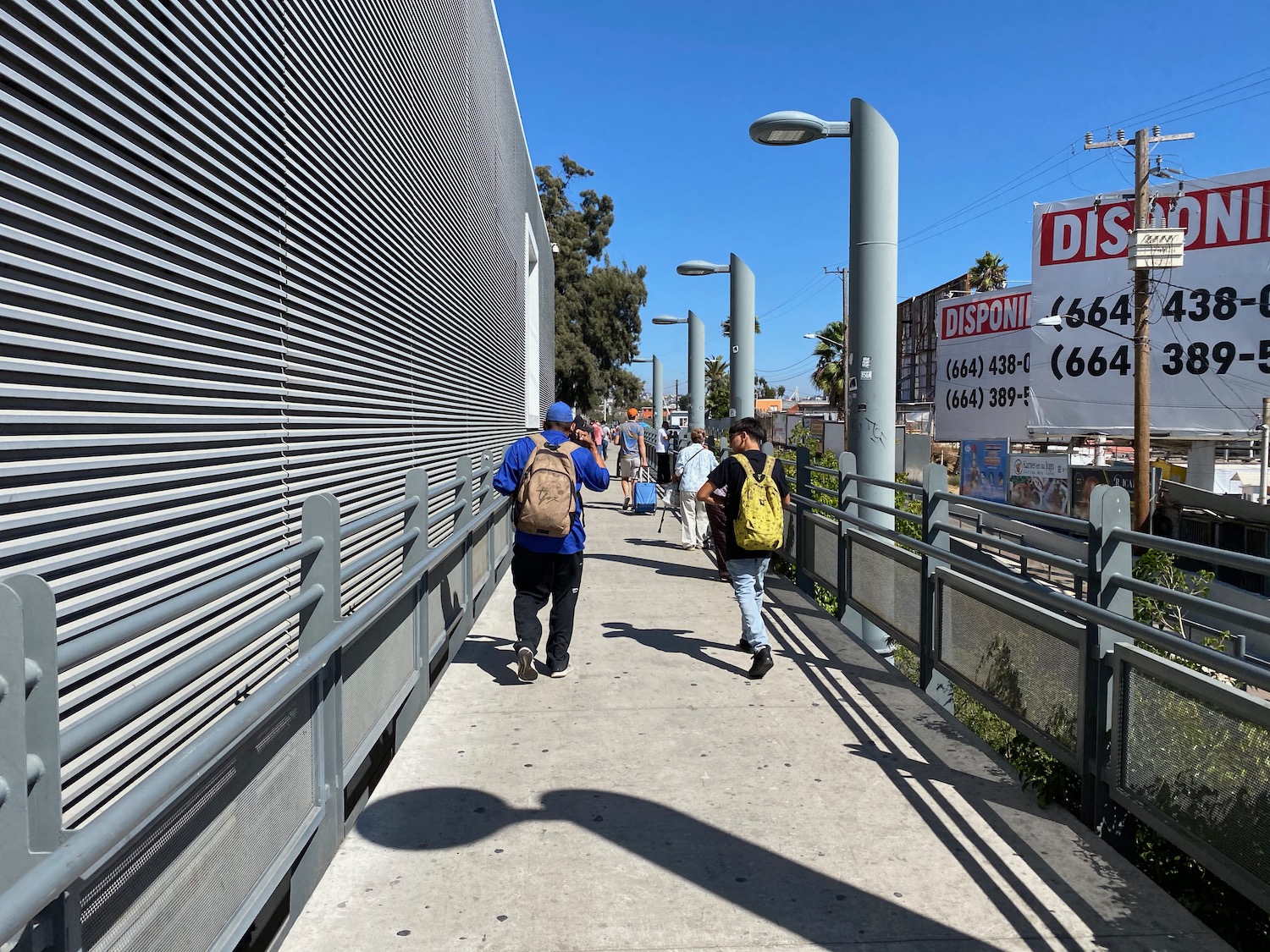 people walking on a walkway with signs