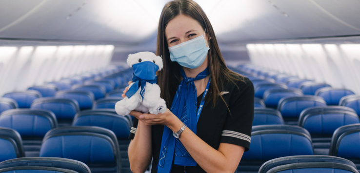 a woman wearing a mask and holding a stuffed animal