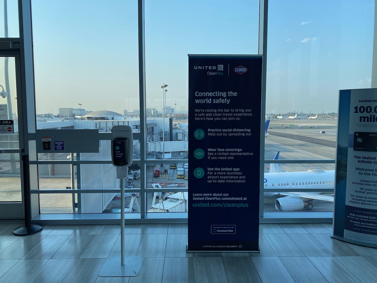 a sign in a room with a window and an airplane in the background