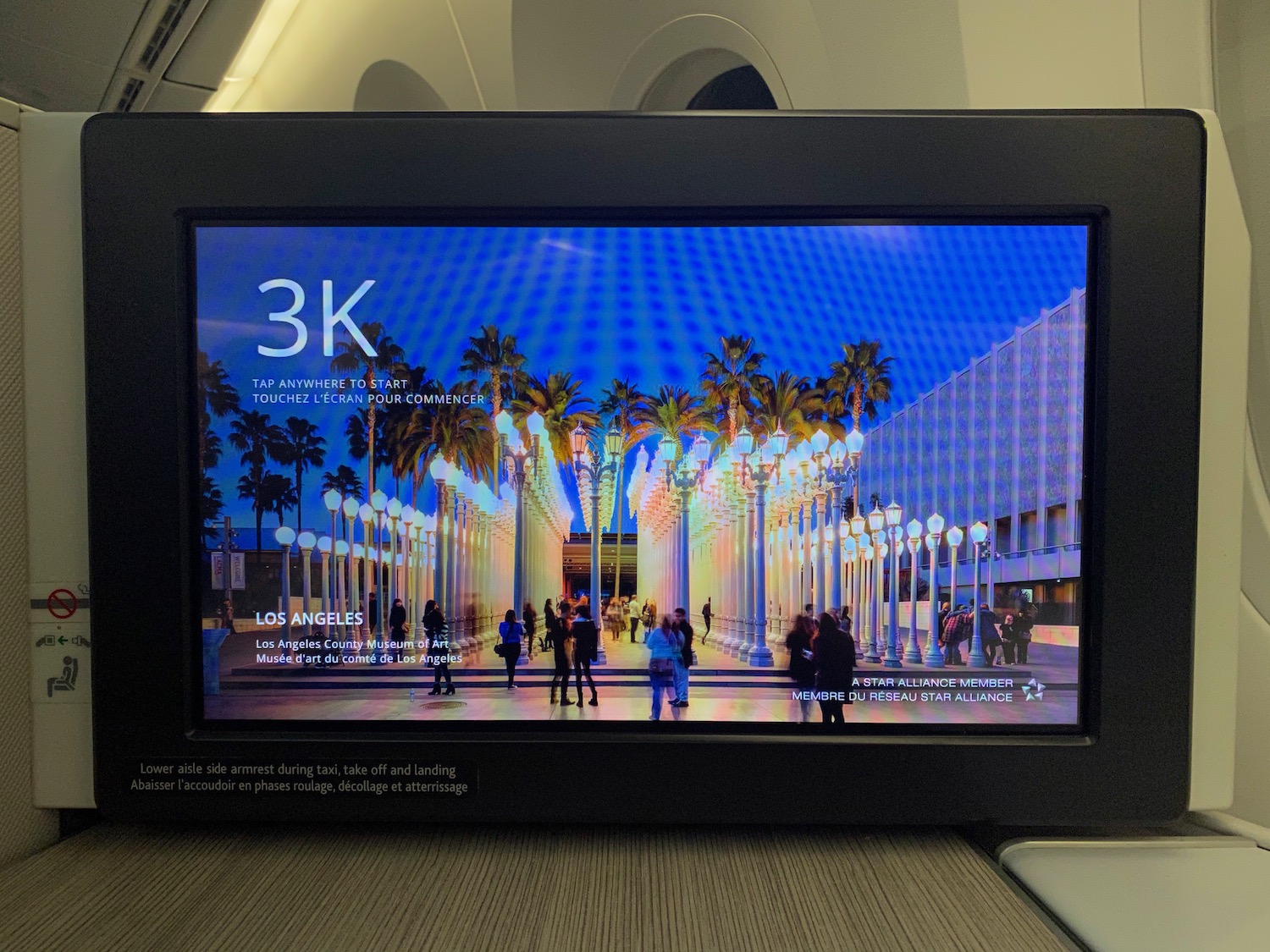 a screen with a picture of a street with palm trees