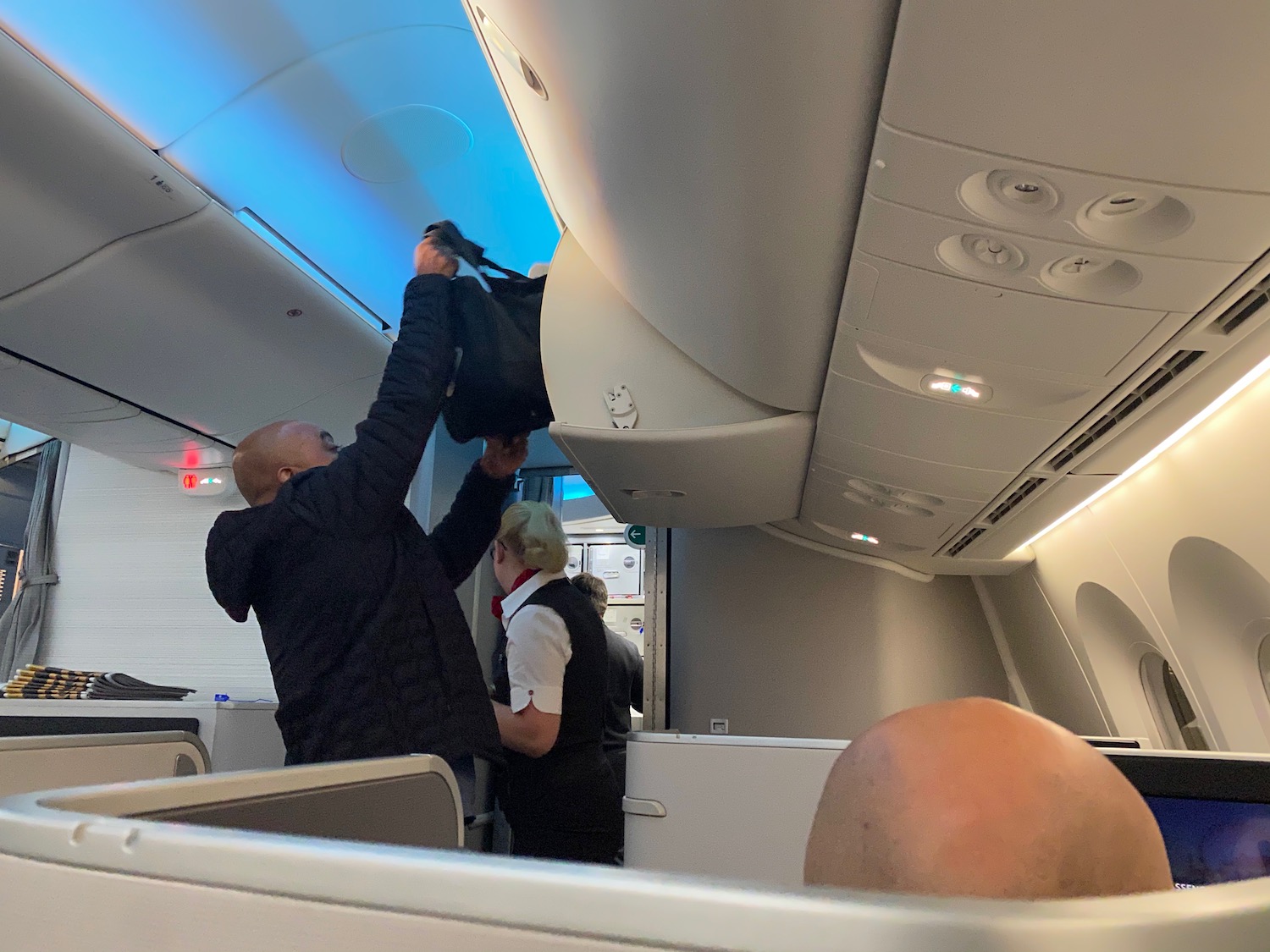 a man holding a bag in an airplane