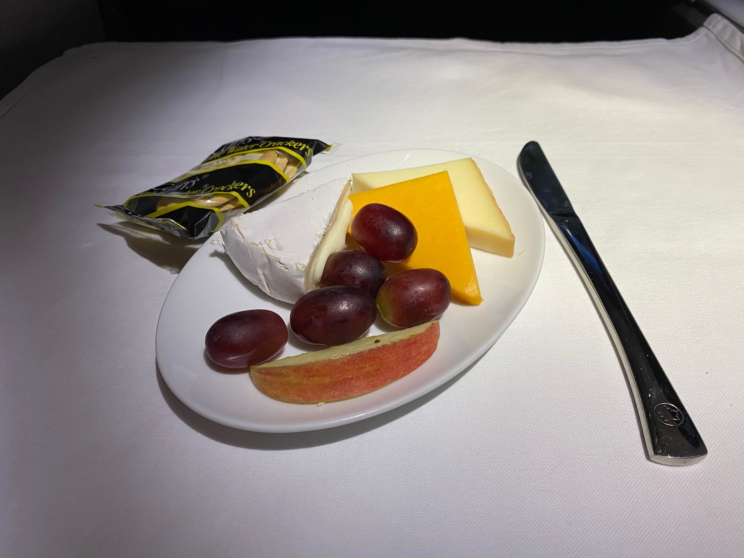 a plate of cheese and grapes on a table