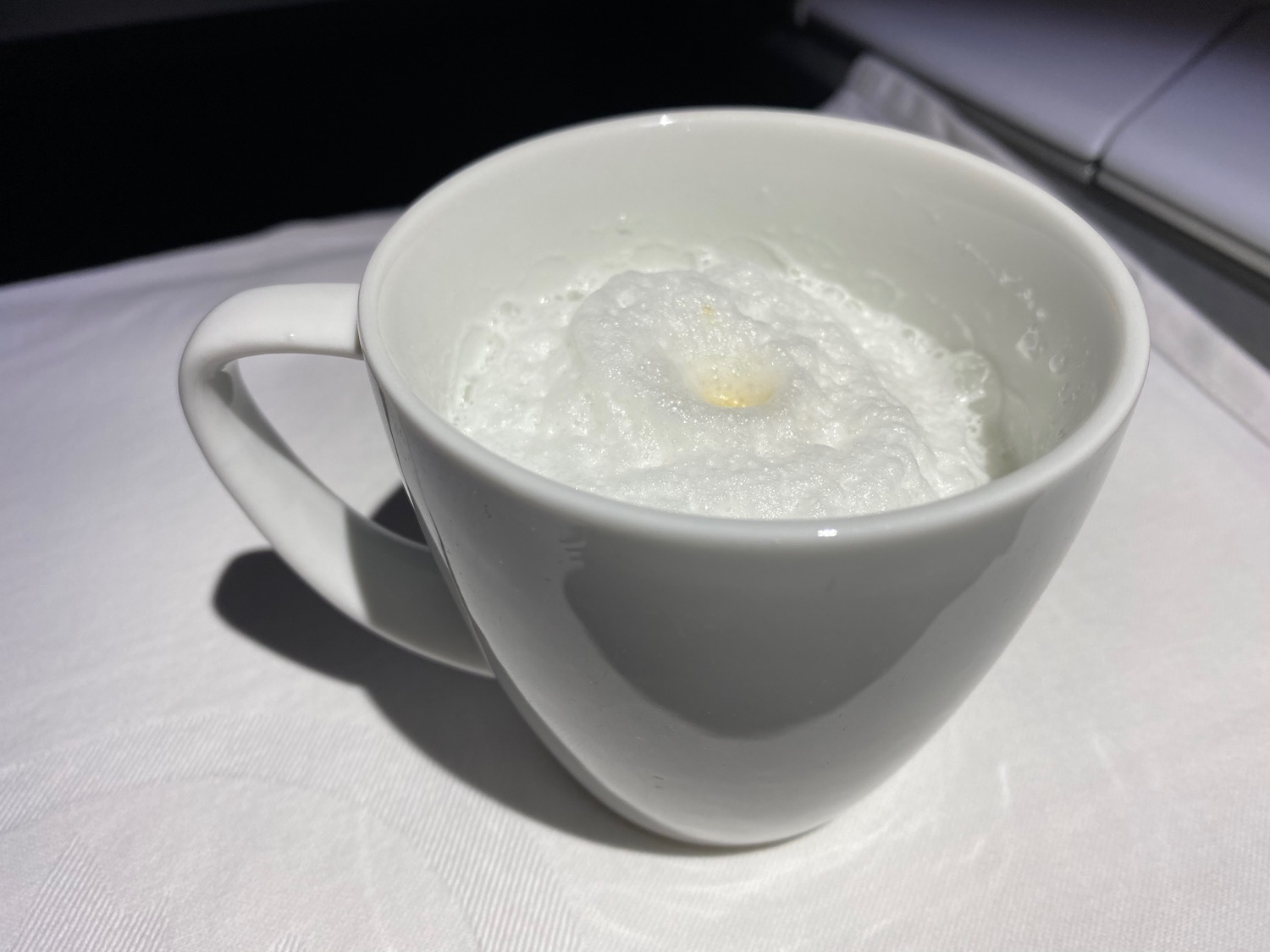 a white cup with foam in it