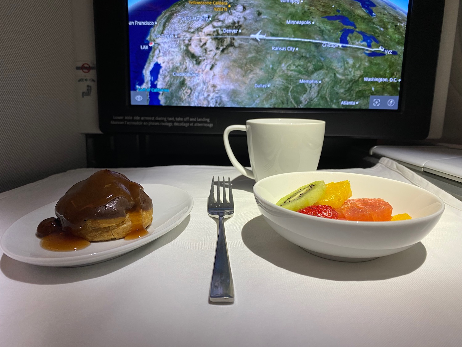 a plate of food and a fork on a table with a television