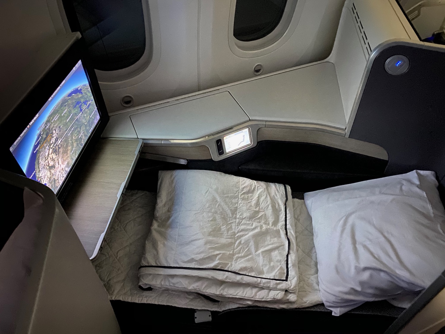a bed with a tv in the back of a plane