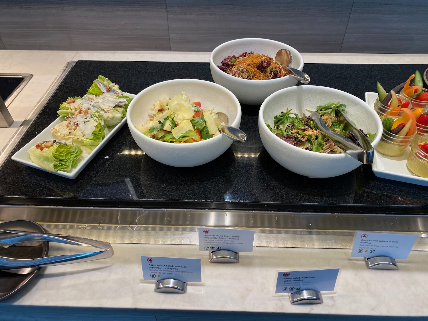 a group of bowls of salad and salad on a counter