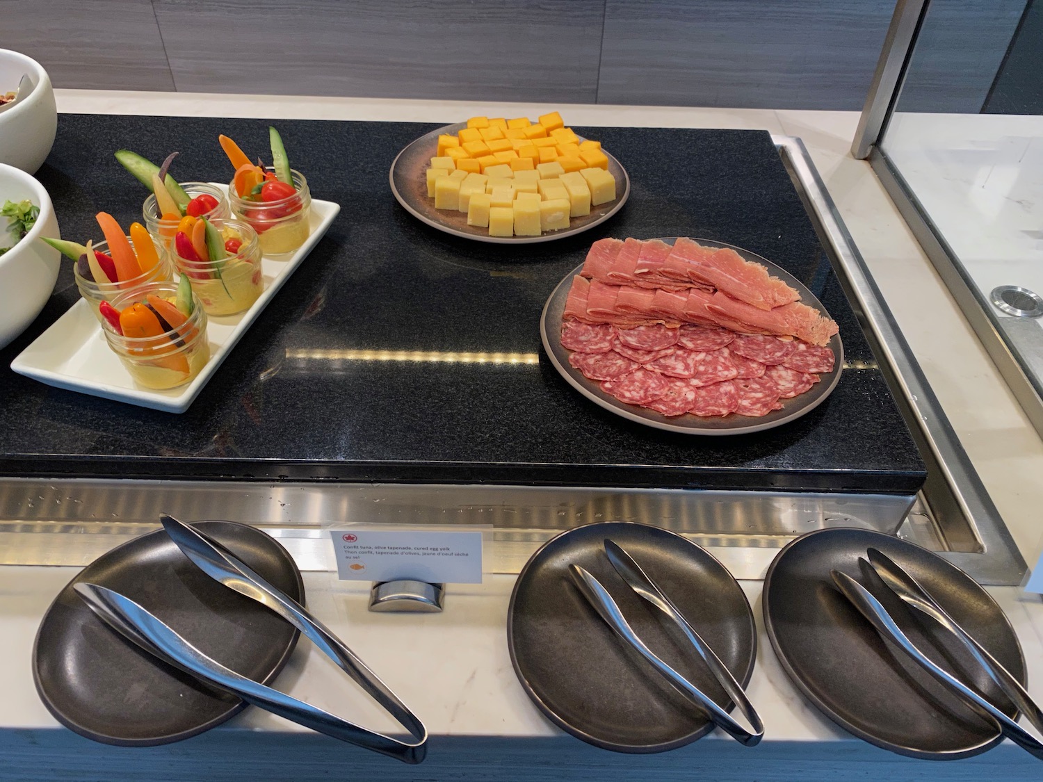 a buffet table with plates of food and utensils