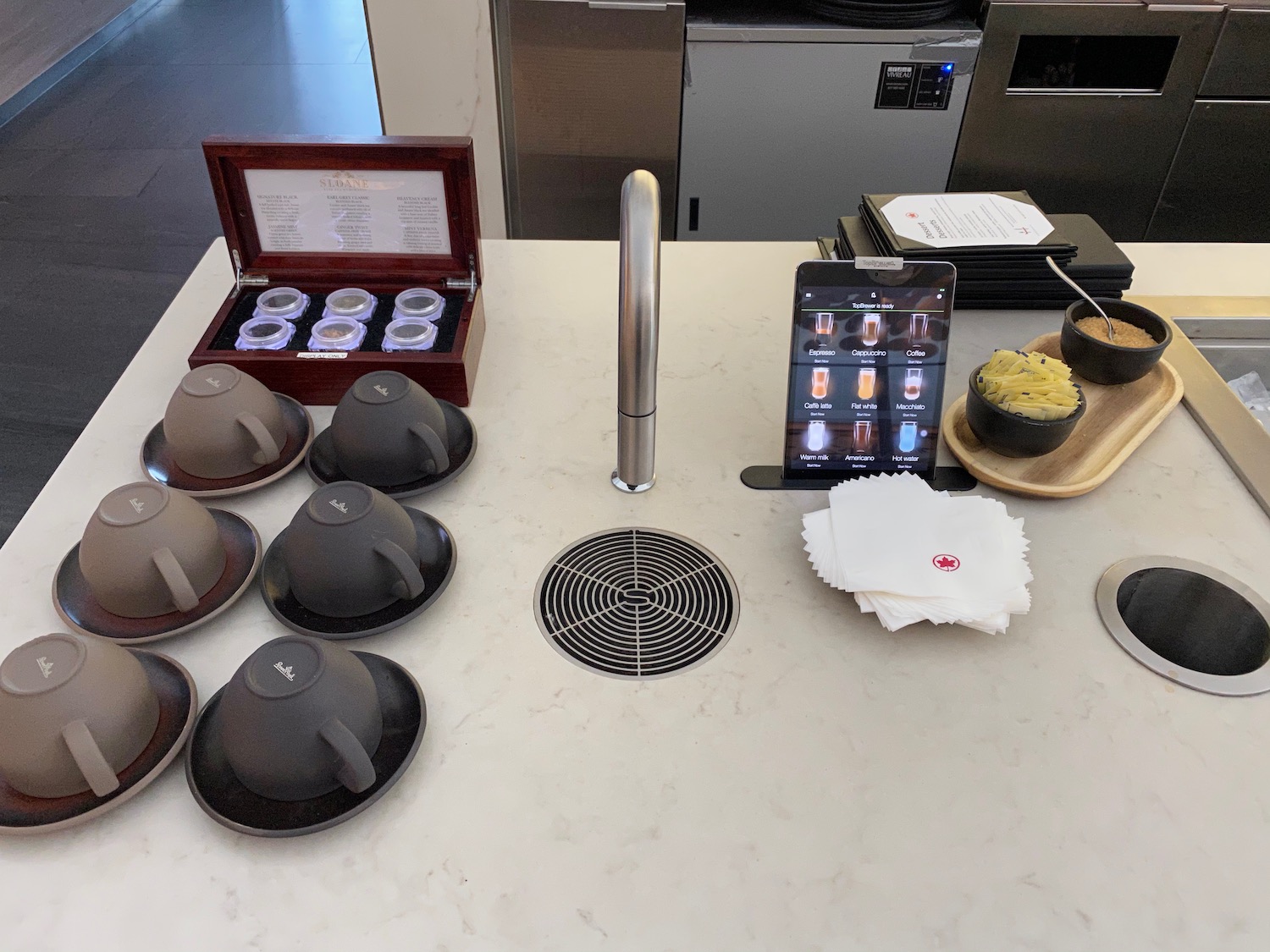 a table with a sink and a group of tea cups and saucers