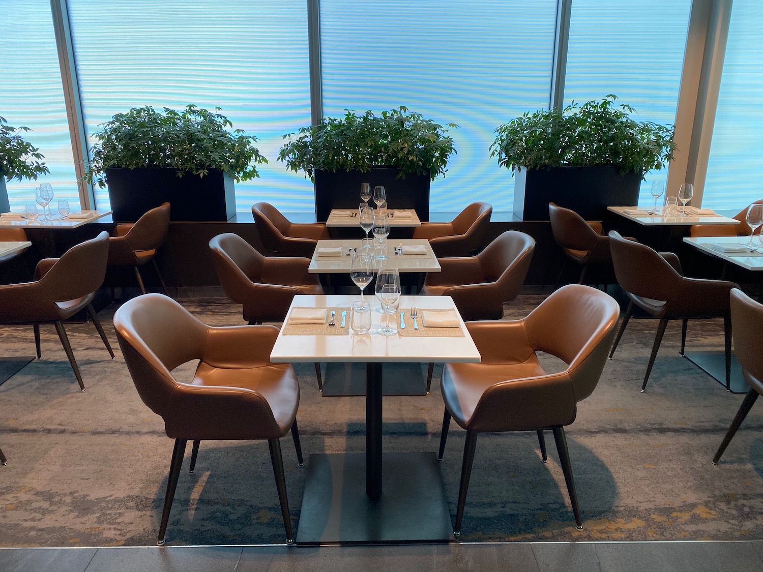 a group of chairs and tables in a room with windows