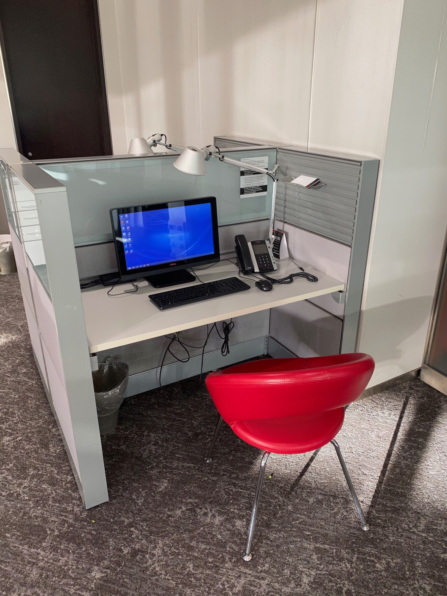 a desk with a computer and a red chair