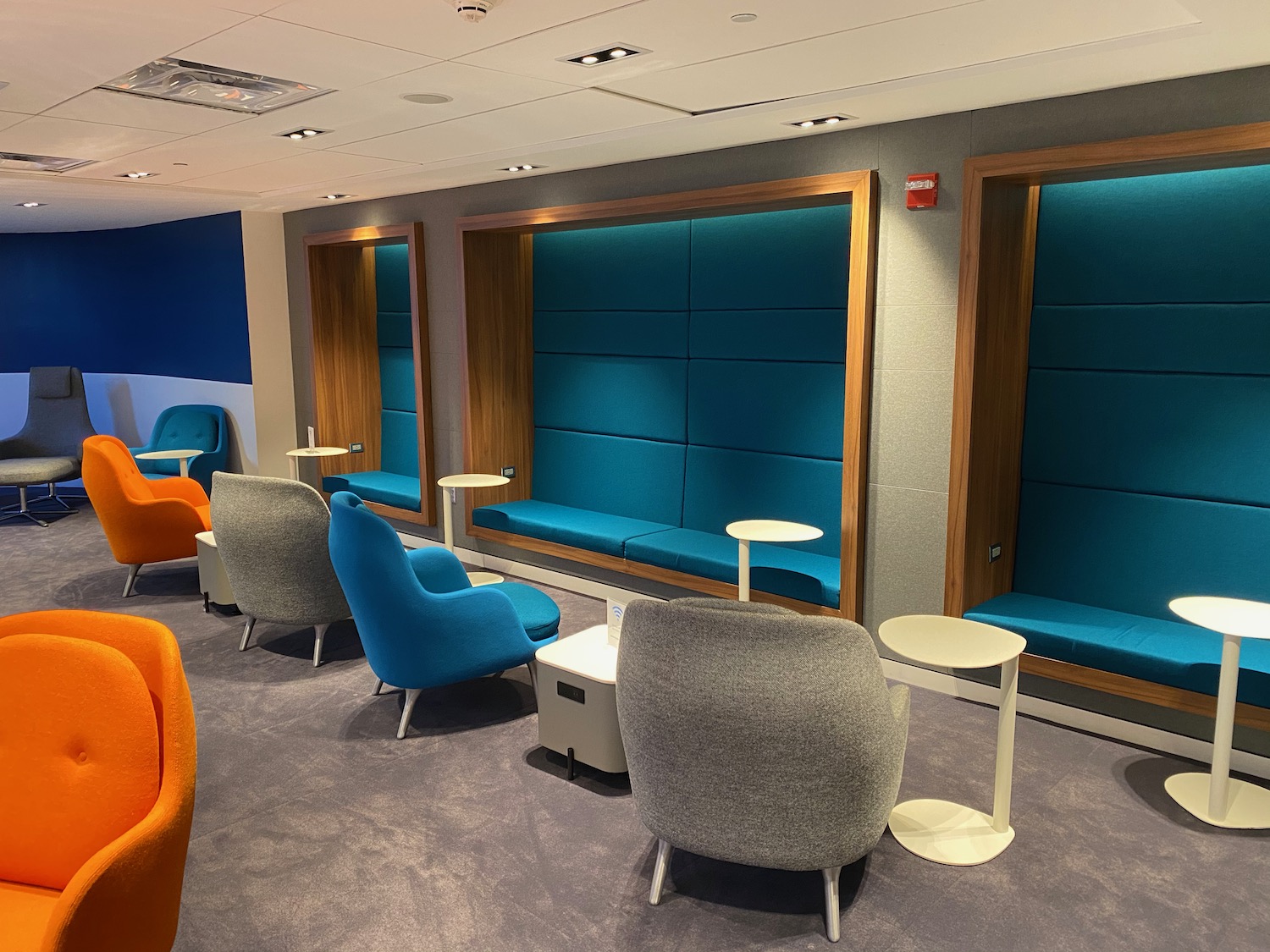 a room with blue and orange chairs and tables