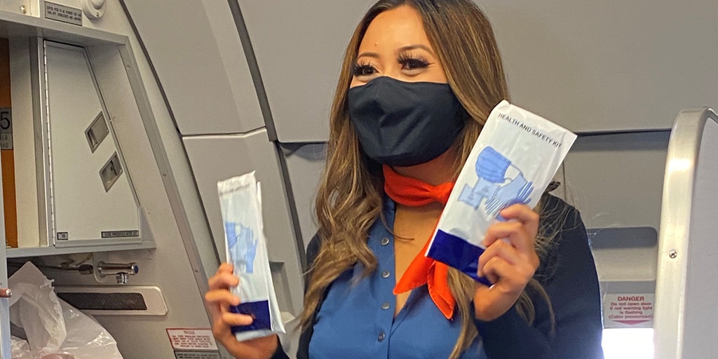 a woman wearing a face mask and holding two packages of tissues
