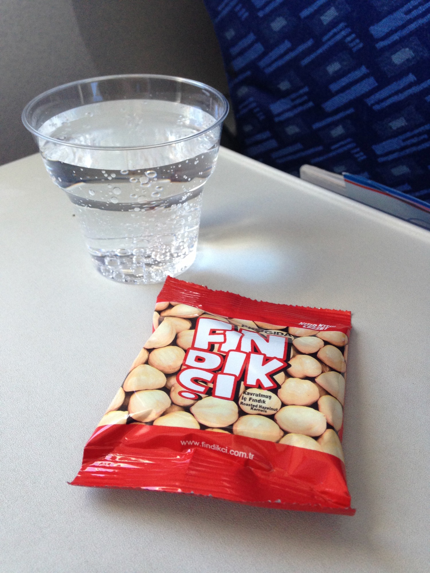 a glass of water and a bag of nuts