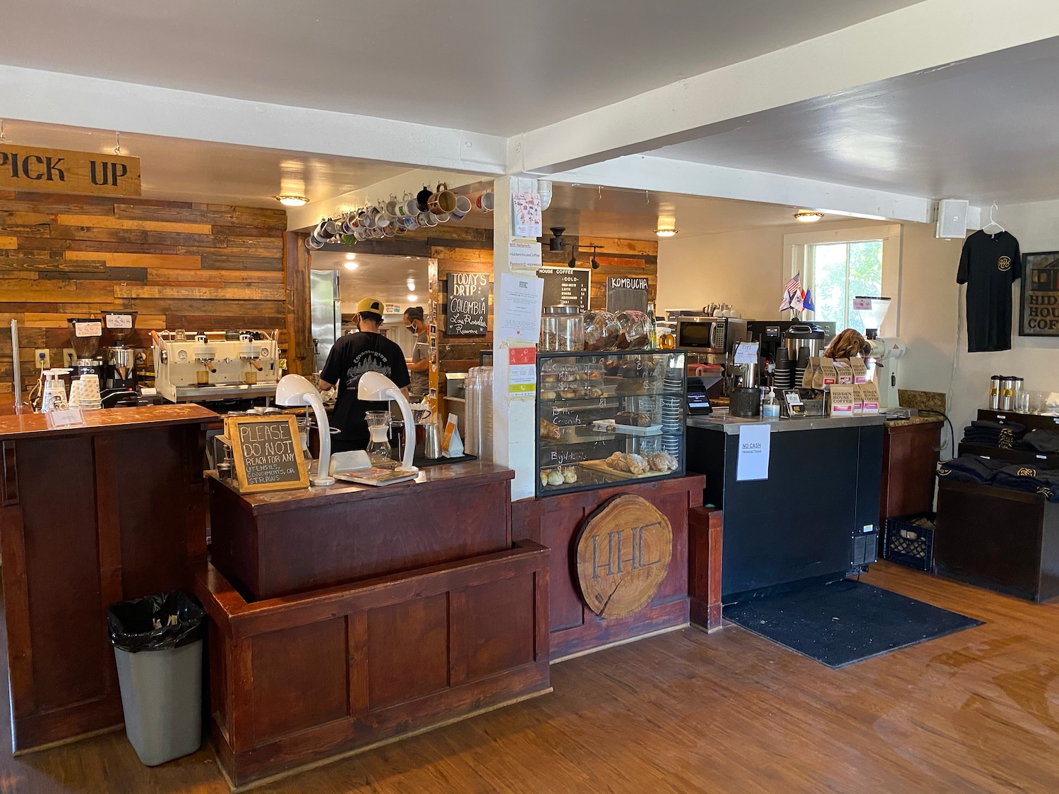 a man standing behind a counter in a coffee shop