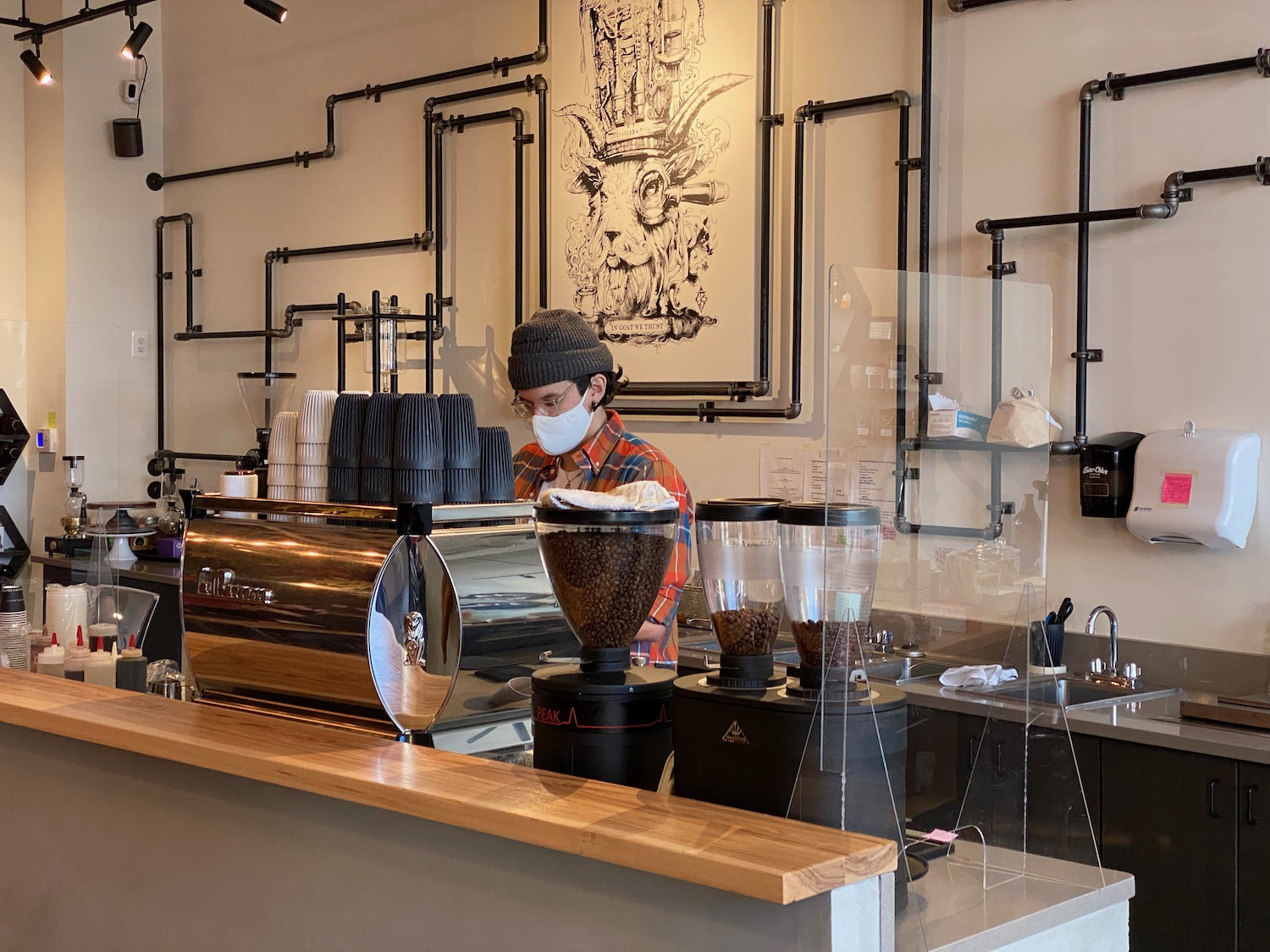 a person behind a counter with coffee beans