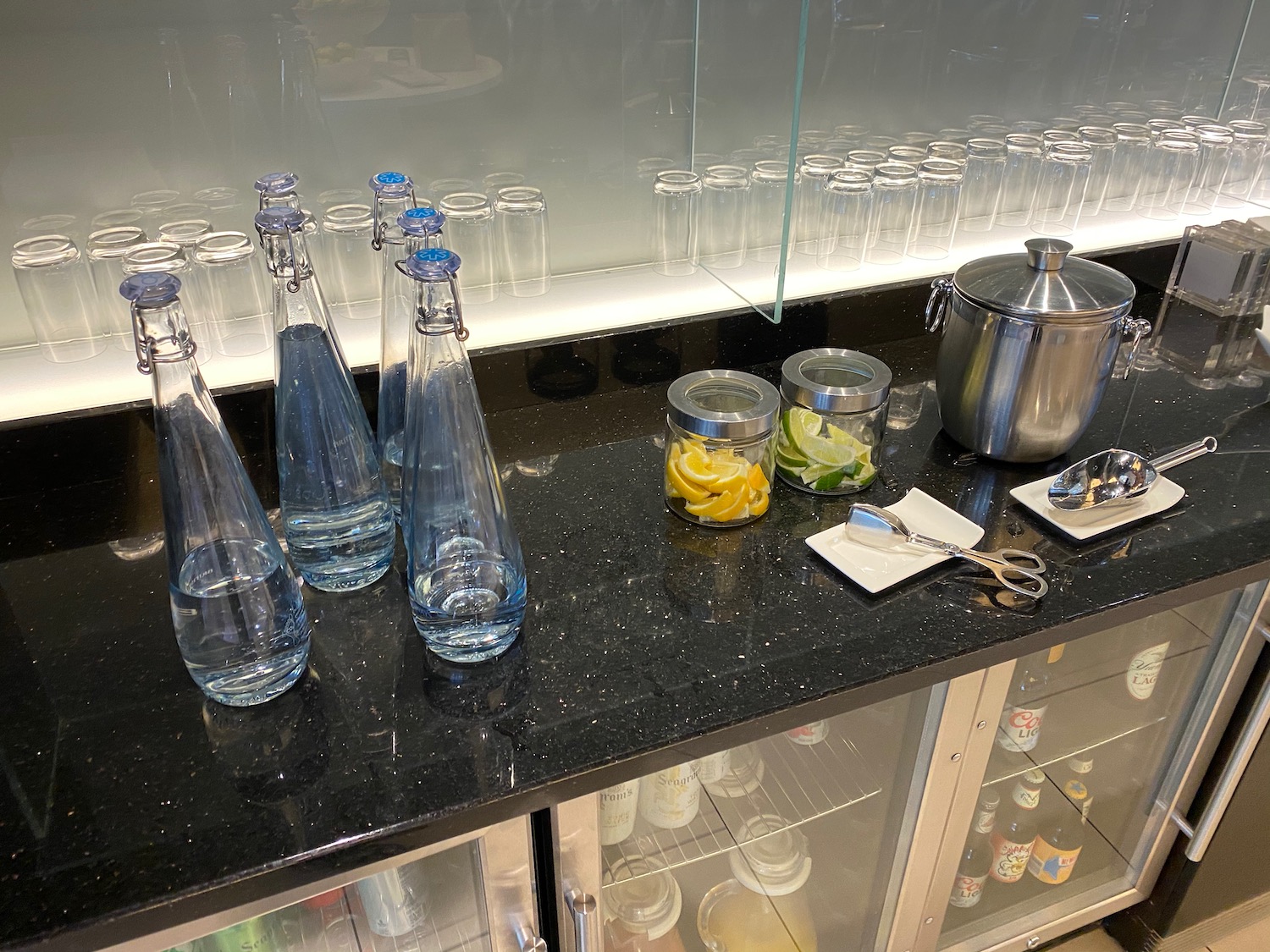 a counter with glass bottles and a jar of lemons