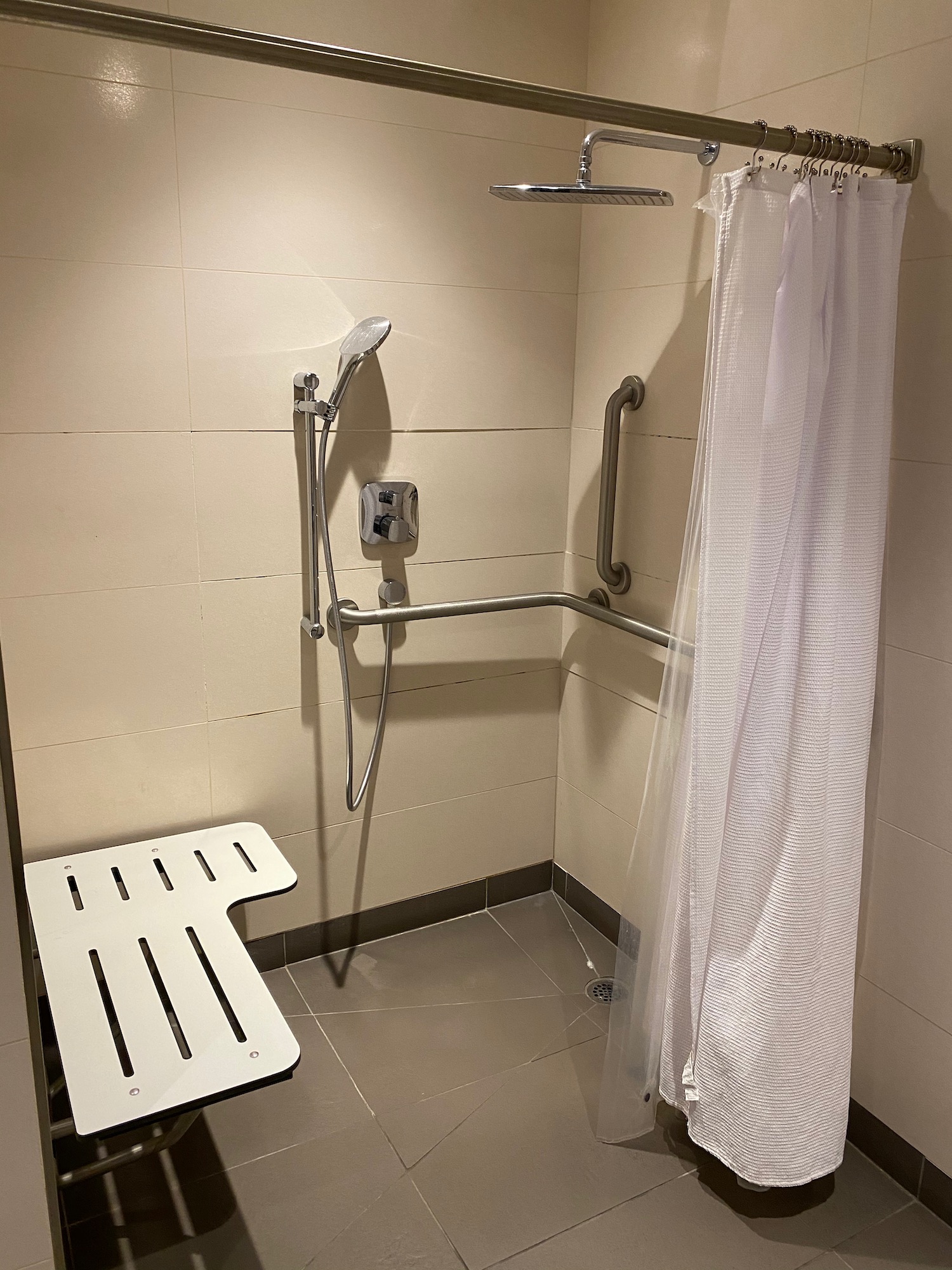 a shower with a shower head and a seat